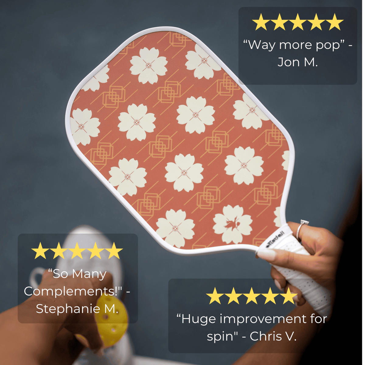 Hand holding a pickleball paddle with floral pattern, surrounded by customer reviews.