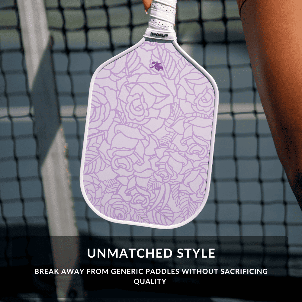 Purple paddle with floral pattern held by a person on a pickleball court, with text about unmatched style.