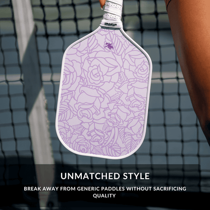 Purple paddle with floral pattern held by a person on a pickleball court, with text about unmatched style.