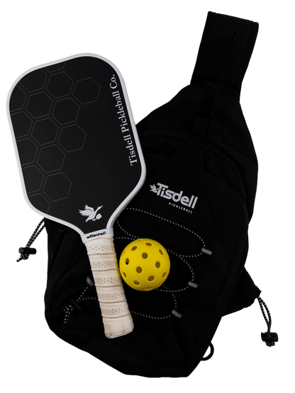 Tisdell pickleball paddle and yellow ball with black bag on a transparent background