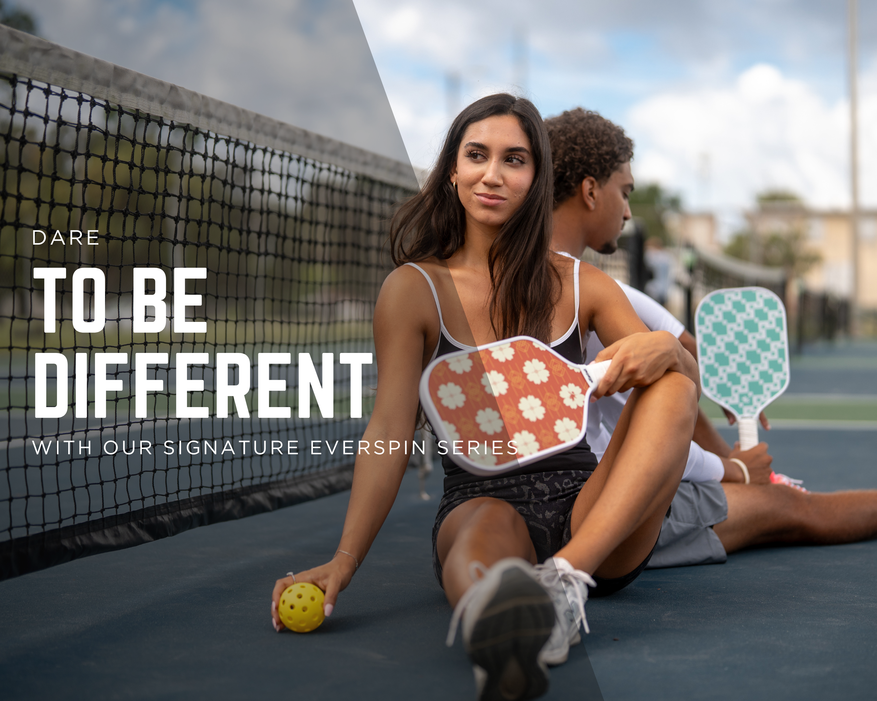 Man and Woman sitting on a pickleball court, she is holding a Tisdell Red Floral pickleball paddle and ball and he is holding a Tisdell Knit green pickleball paddle