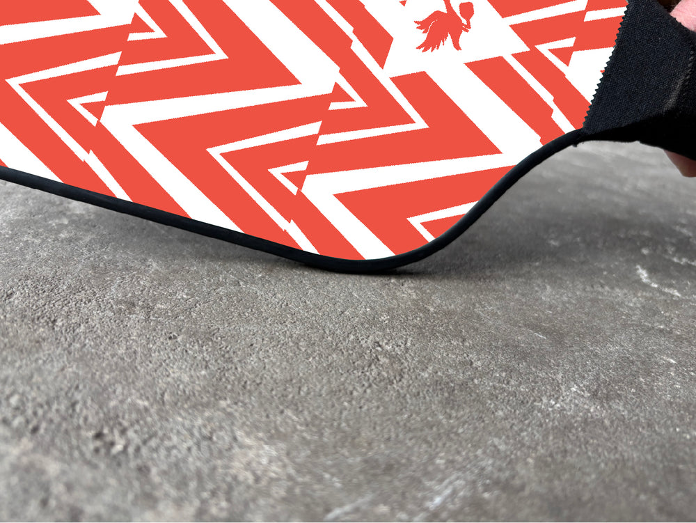 Tisdell wooden pickleball paddle with a red and white zig-zag design on a grey background. 