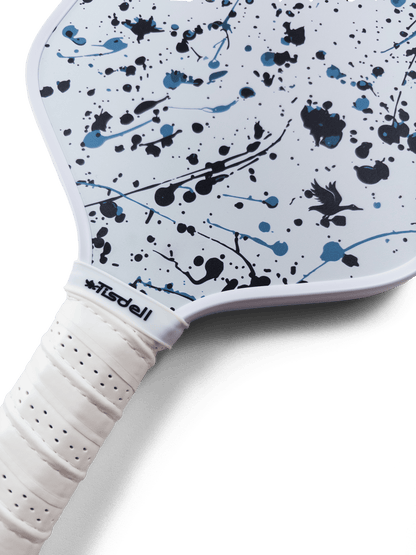 Pickleball paddle with white handle and splatter pattern on a transparent background